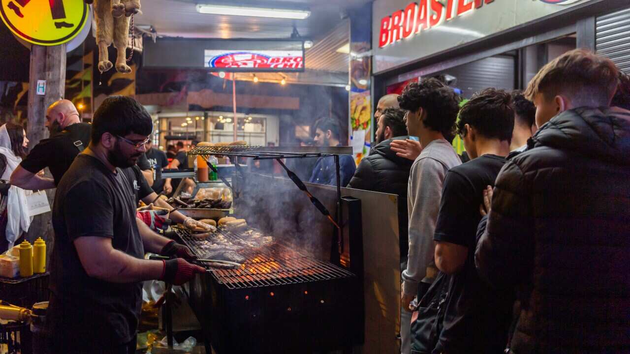 People queuing at a food stall at night
