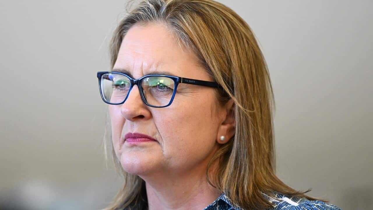 A woman with black glasses and a blue and white top