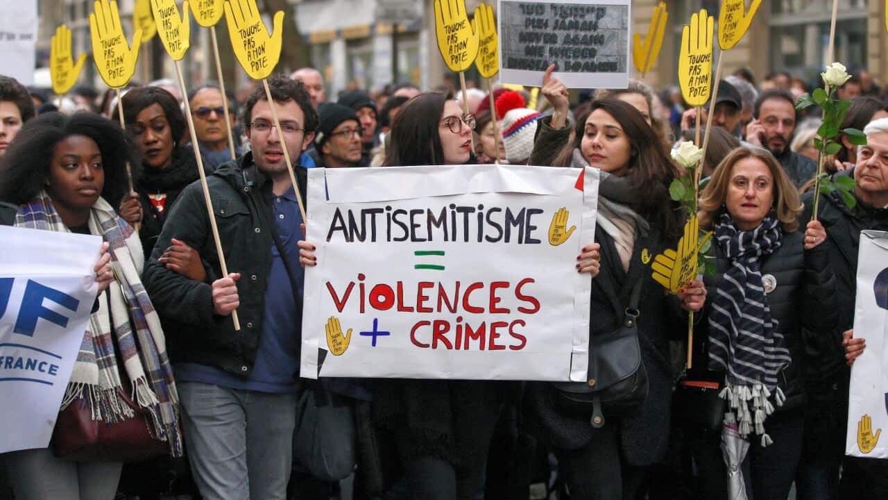 Demonstrators hold signs against anti-Semitism during a silent march in Paris on March 28, 2018.