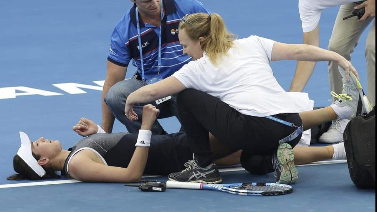 Garbine Muguruza treated by medical staff after she suffered cramps.