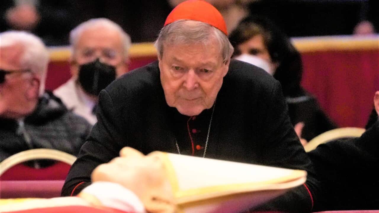Australian Cardinal George Pell stands next to the body of late Pope Benedict XVI lying in state inside St. Peter's Basilica at The Vatican, Tuesday, Jan. 3, 2023. Pell, who was the most senior Catholic cleric to be convicted of child sex abuse before his convictions were later overturned, has died Tuesday, Jan. 10, 2023, in Rome at age 81. (AP Photo/Gregorio Borgia, File)
