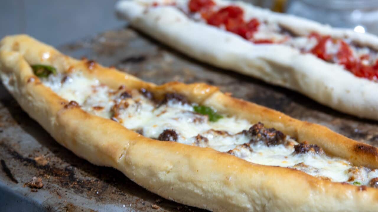 Traditional homemade Italian pizza on a hot iron oven and Turkish pita with tomato sauce in dough ready to bake