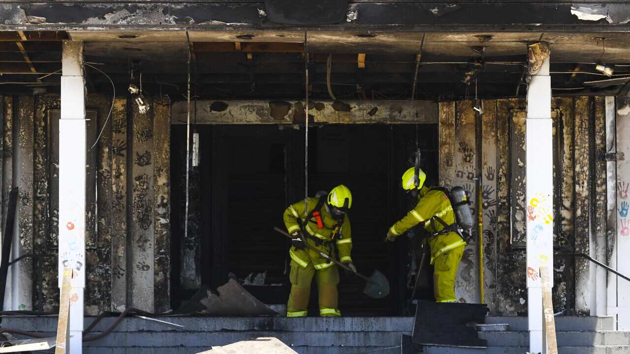 Firefighters are seen entering the fire damaged entrance to Old Parliament House in Canberra