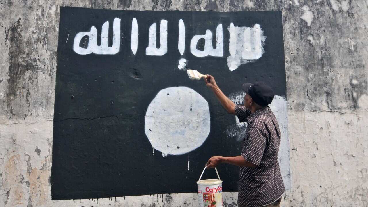 Indonesia worker removes ISIS graffiti