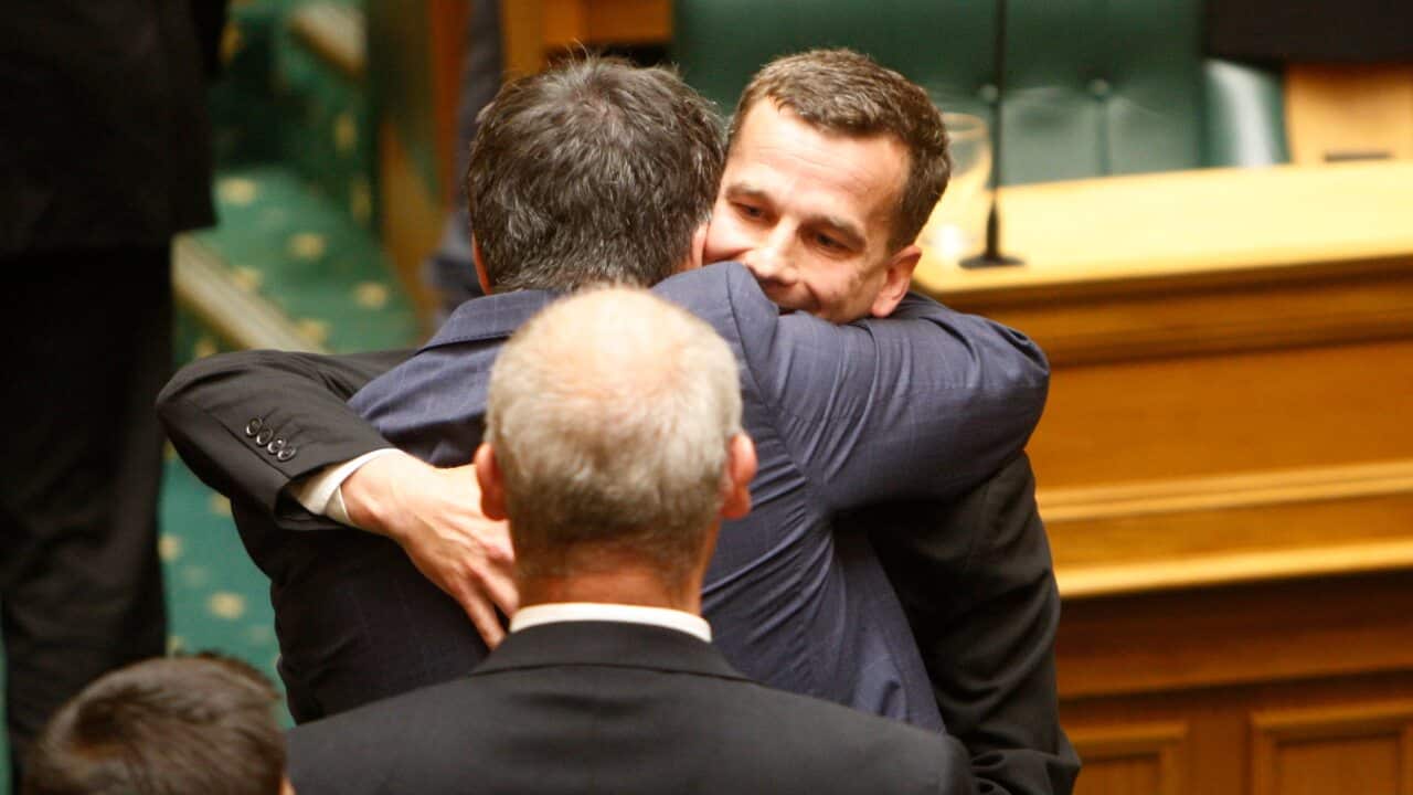 Euthanasia bill sponsor David Seymour (center) embraces other lawmakers in Parliament on Wednesday.