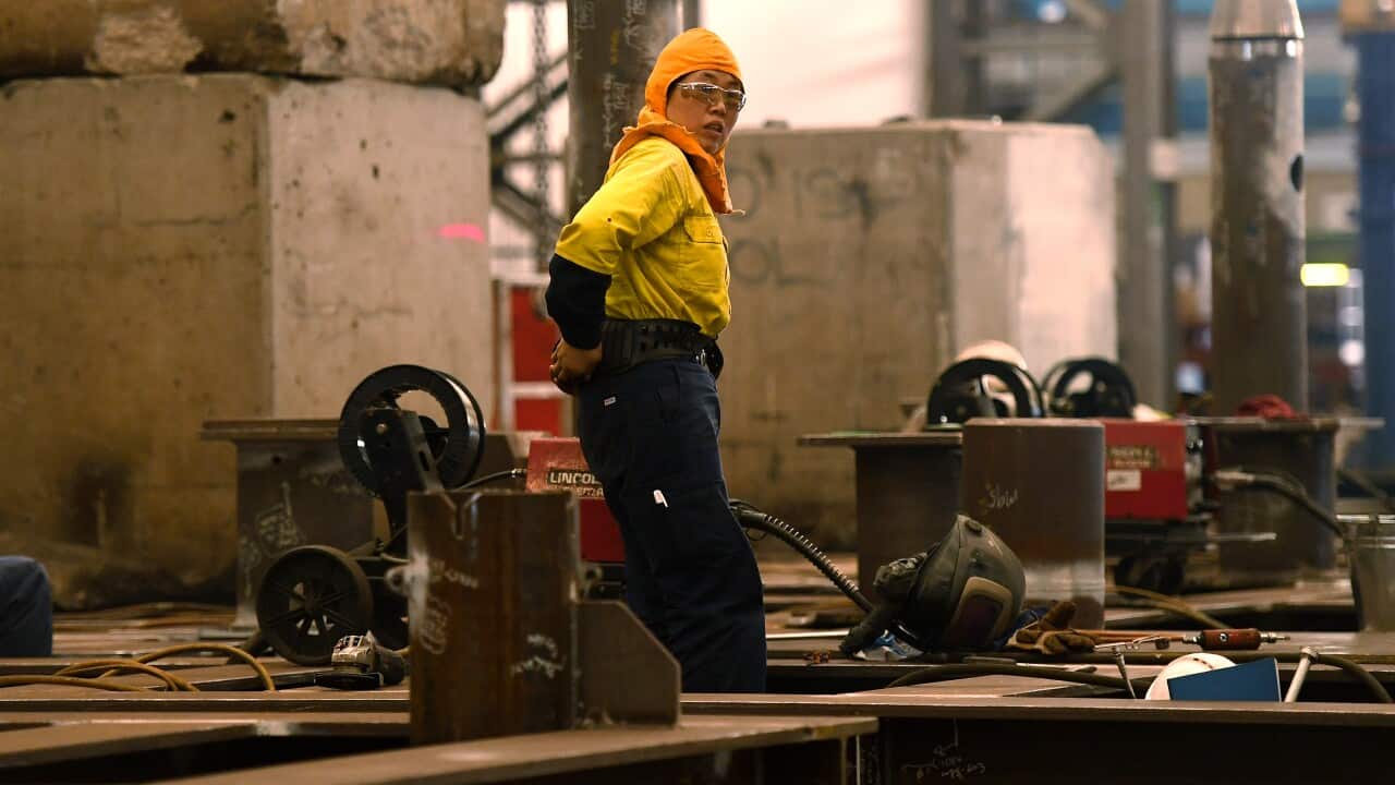 A worker wearing protective gear in an industrial setting.
