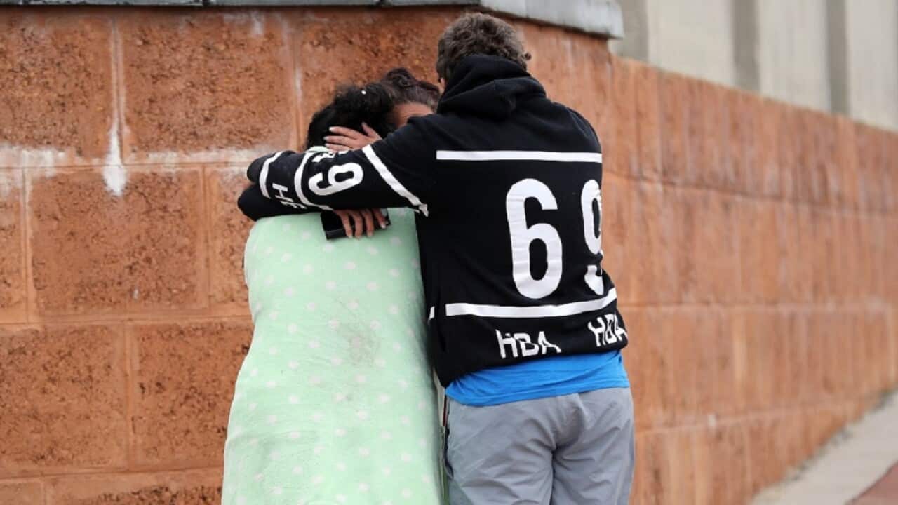 People are seen outside a house where three people have been found dead in Ellenbrook, Perth.