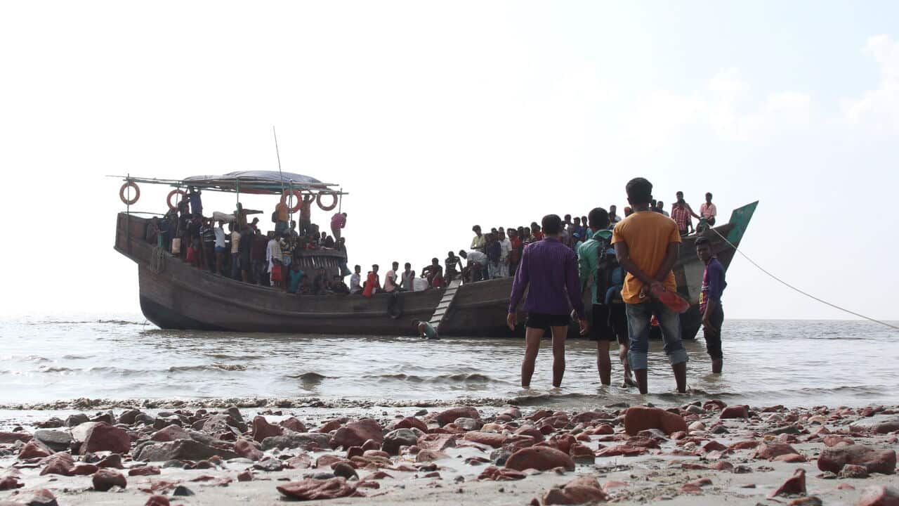 People getting off a boat in Bhashan Char island off the Bangladeshi coast prepared for the relocation of Rohingya refugees.
