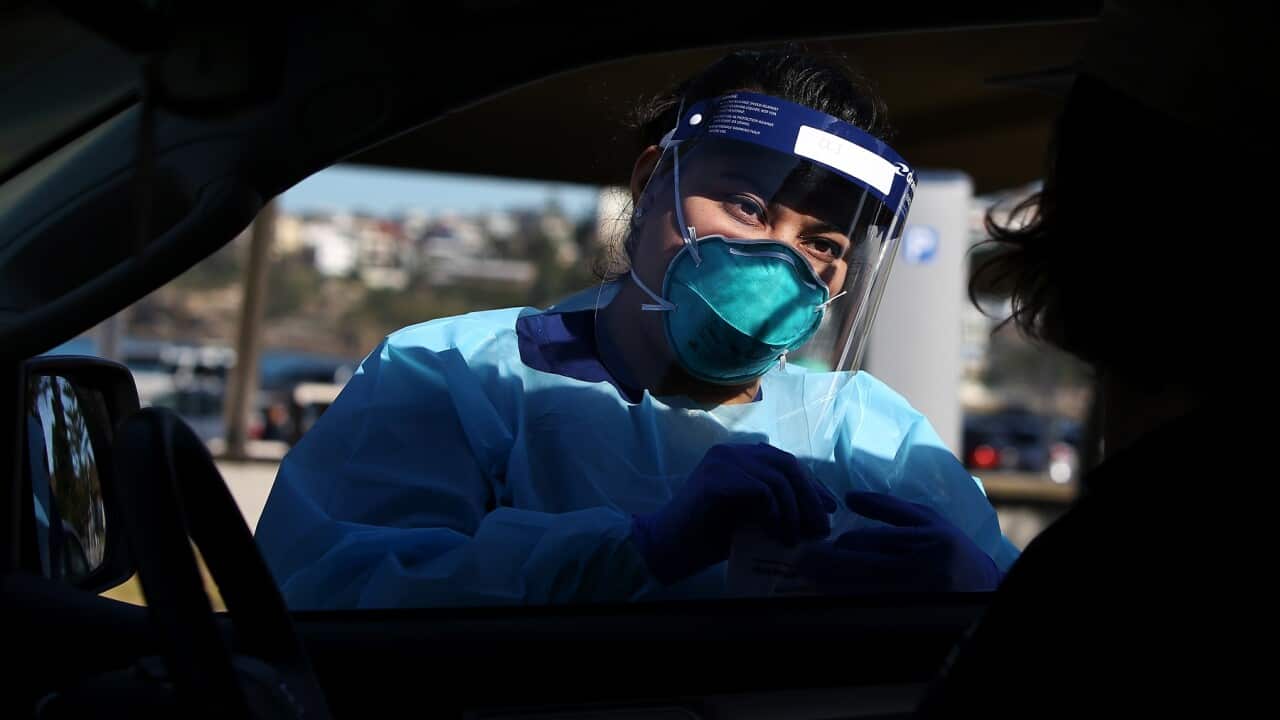 Registered Nurse Oli Meeta conducts a COVID-19 swab test at Bondi in Sydney