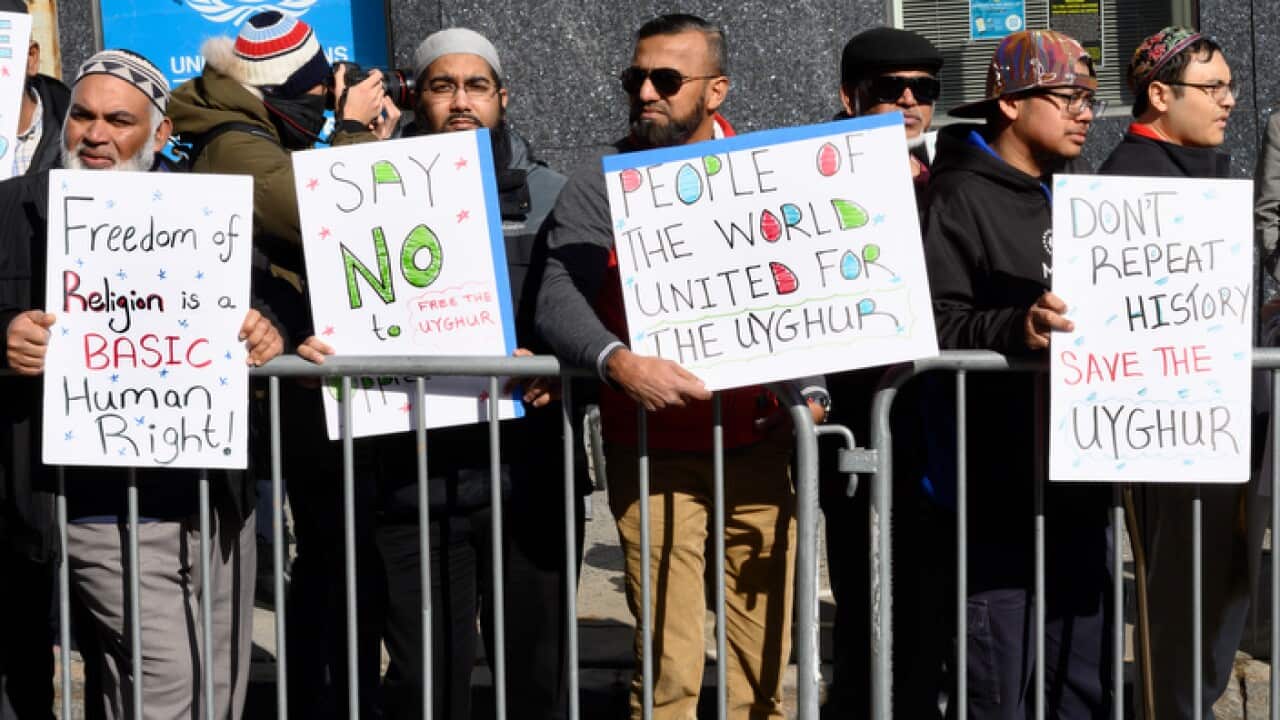 Demonstrators in New York hold placards during the rally to support the Uighur community in China.