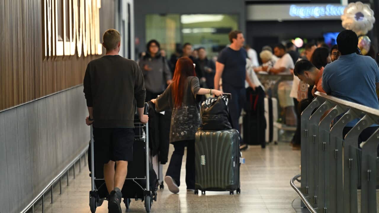 Airline travellers walking through an arrival gate at Melbourne Airport