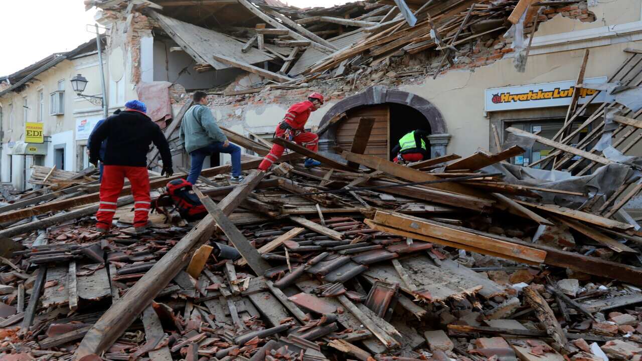 Workers clear a building damaged in an earthquake in Petrinja, Croatia.