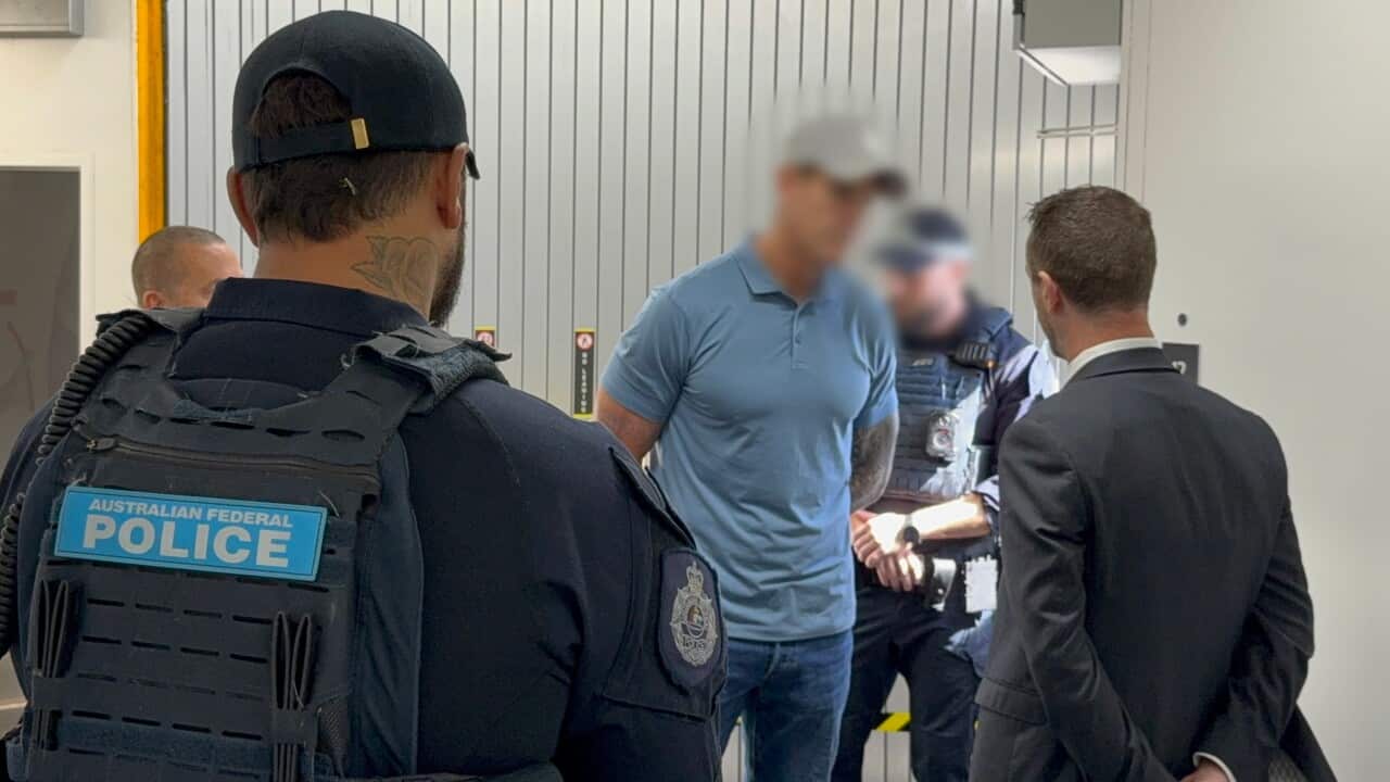 Police officers speaking to a man.