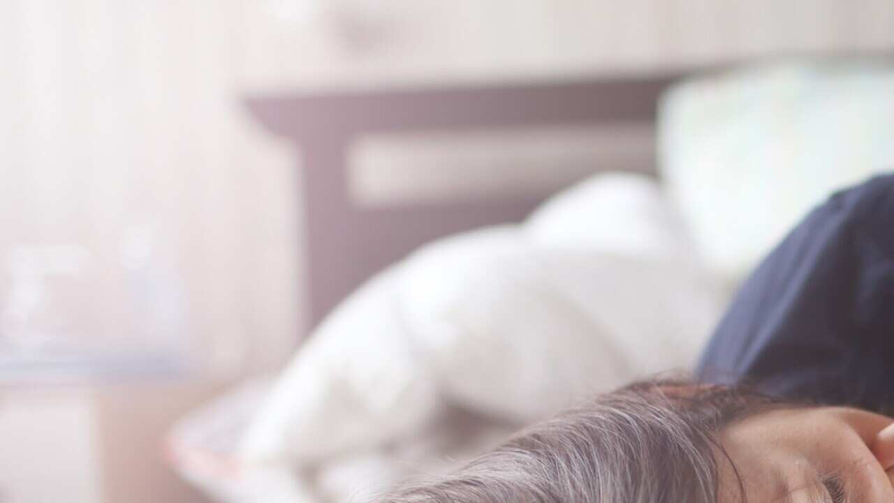 A mum playing with her son on a bed