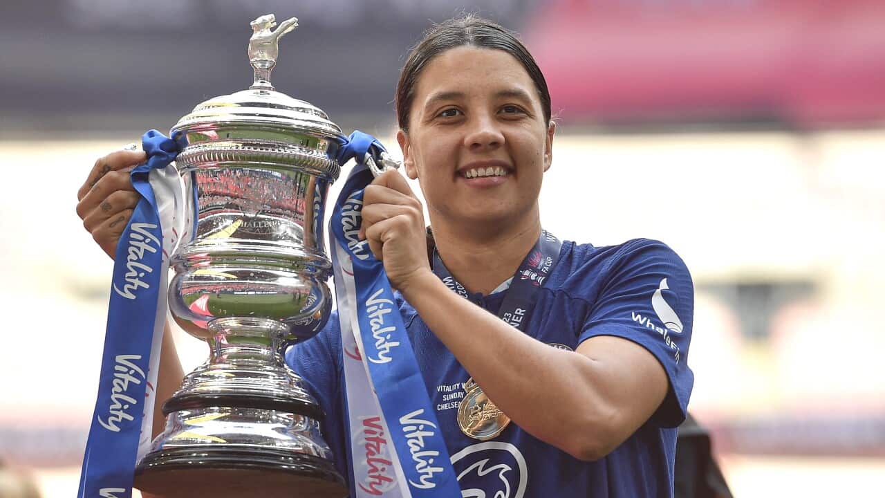 A woman holding up a trophy