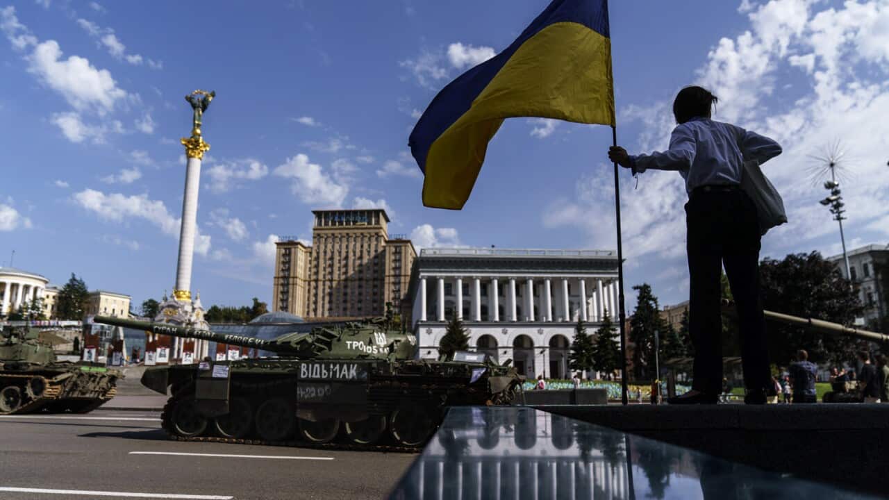 A woman holds a flag of Ukraine in Kyiv
