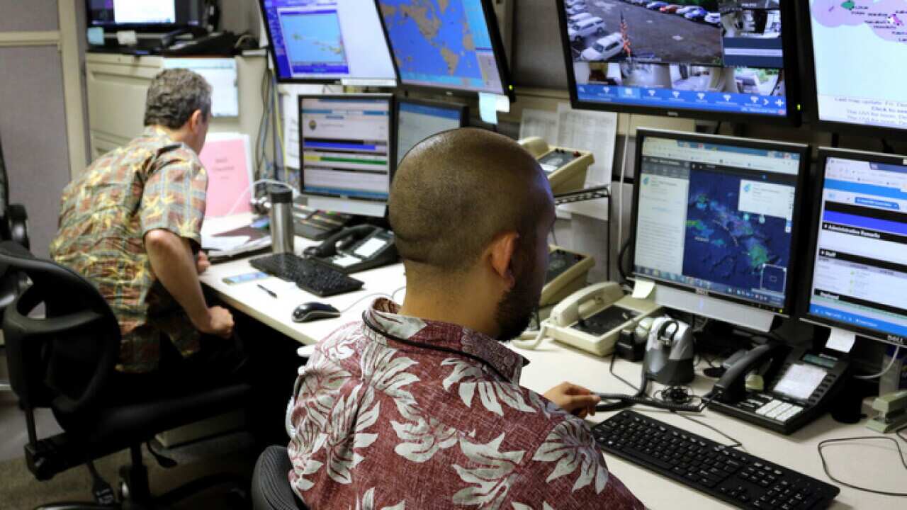 Hawaii Emergency Management Agency officials work at the department's command center in Honolulu.