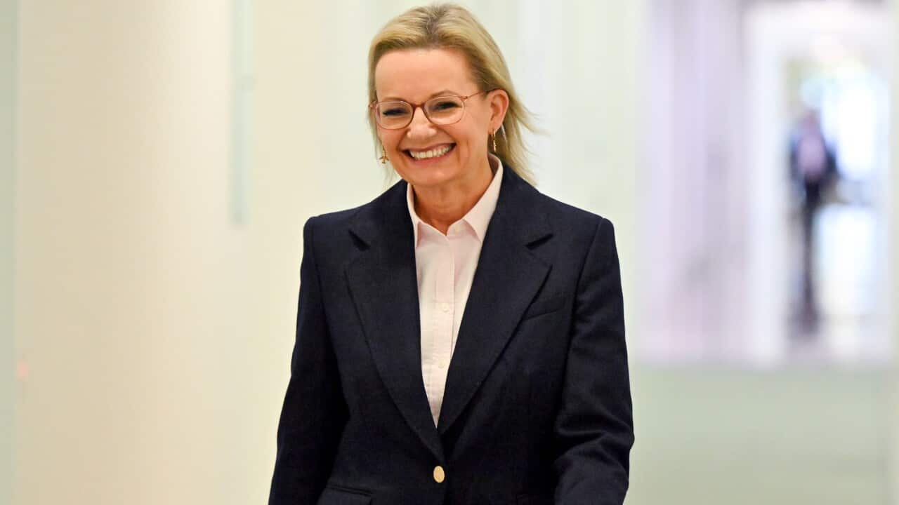 Opposition leader Sussan Ley smiling as she walks down a hallway.