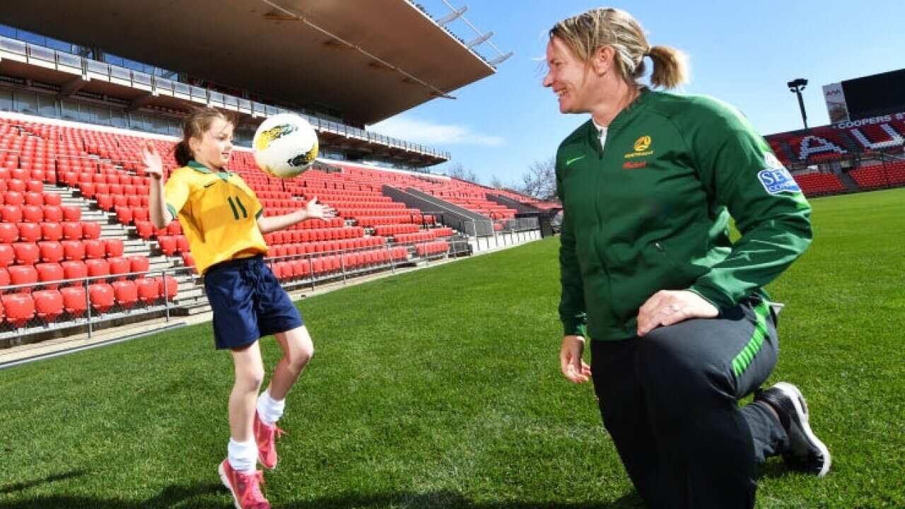 Matildas assistant coach Melissa Andreatta poses with a young Matildas fan