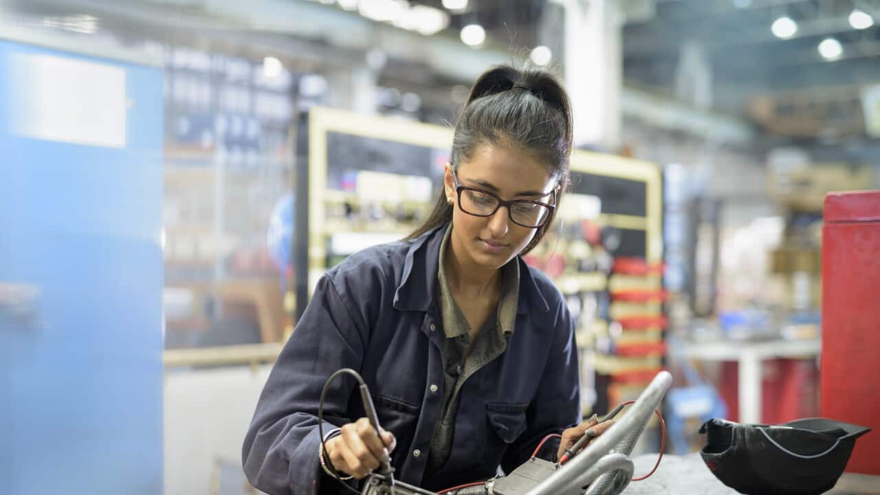 Female apprentice electrician in car factory