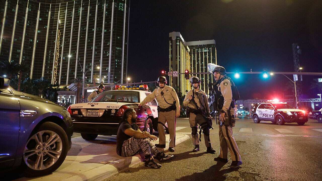 Police officers stand at the scene of a shooting near the Mandalay Bay resort and casino on the Las Vegas Strip, Sunday, Oct. 1, 2017, in Las Vegas.
