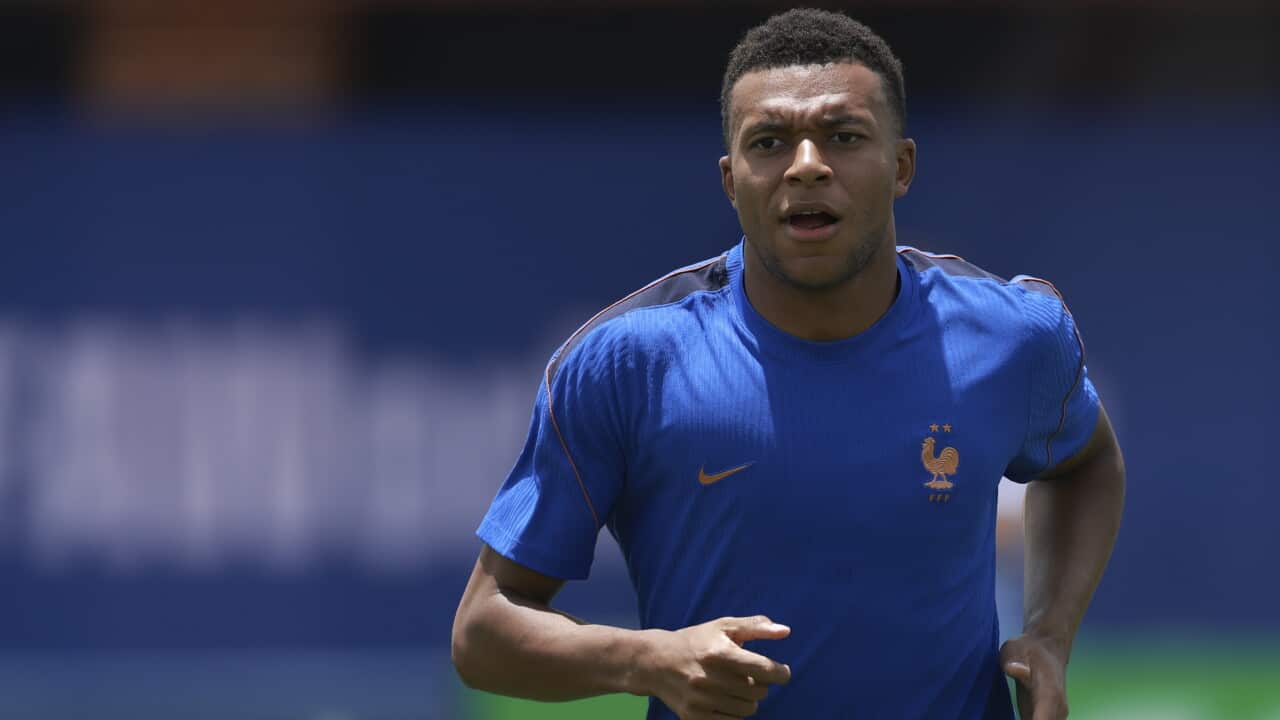 France striker Kylian Mbappé running in a blue training top
