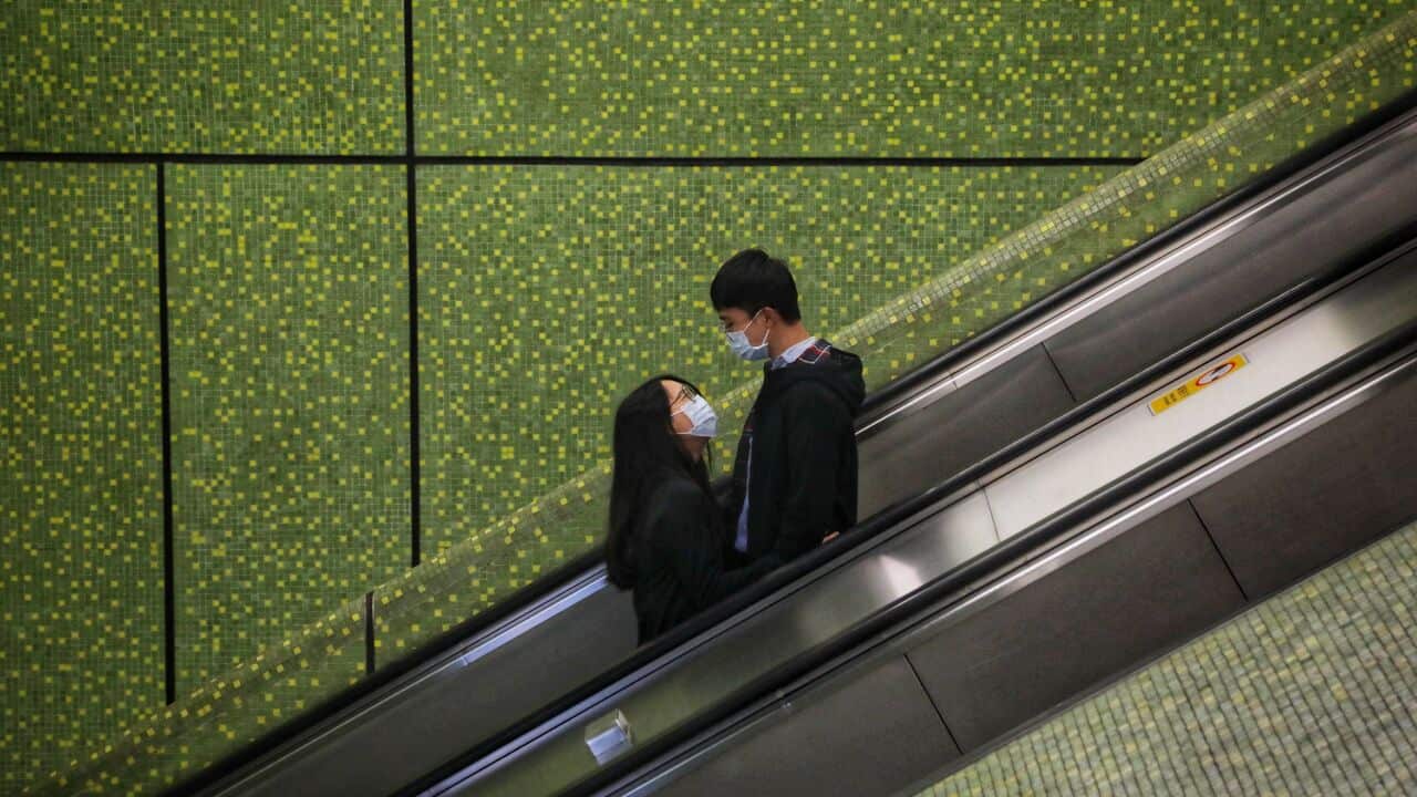 A couple wear face masks during the evening rush hour.