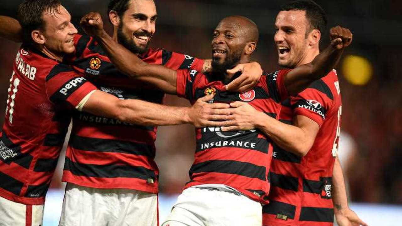 Romeo Castelen of the Wanderers, (second right), celebrates with team mates after scoring his third goal during the A-League semi-final