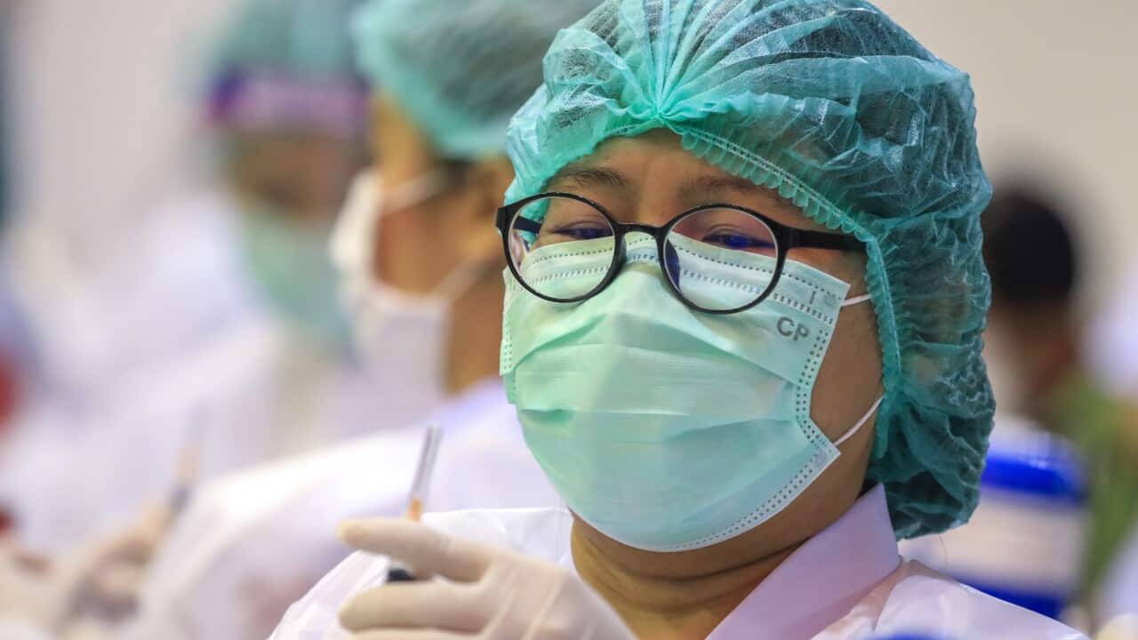 A Thai health official administers the Sinovac vaccine to Bangkok shopping mall staff