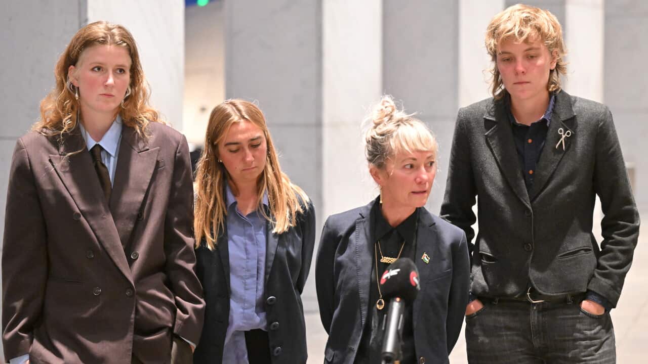 Four Global Sumud activists in suits outside Parliament House in Canberra on Monday