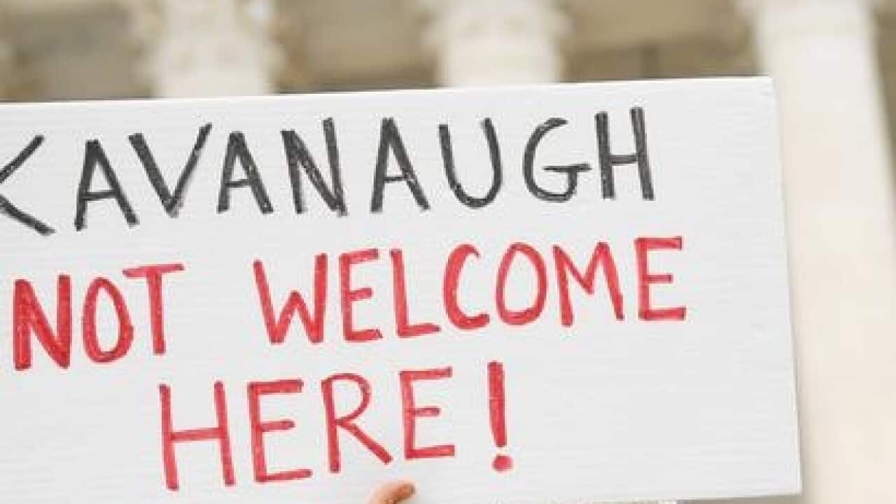Protestors gathered outside the US Supreme Court on the morning of Brett Kavanaugh's first day. (AAP)