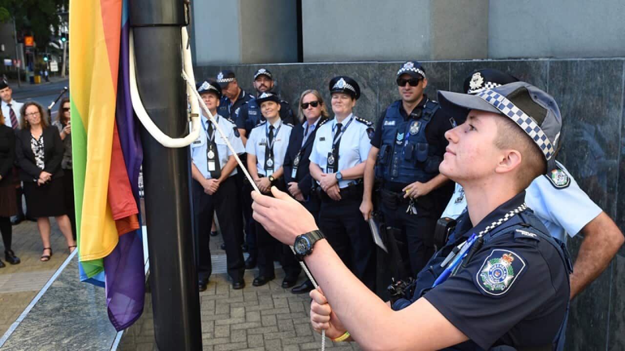 Constable Mairead Devlin raises a rainbow flag at Police headquarters