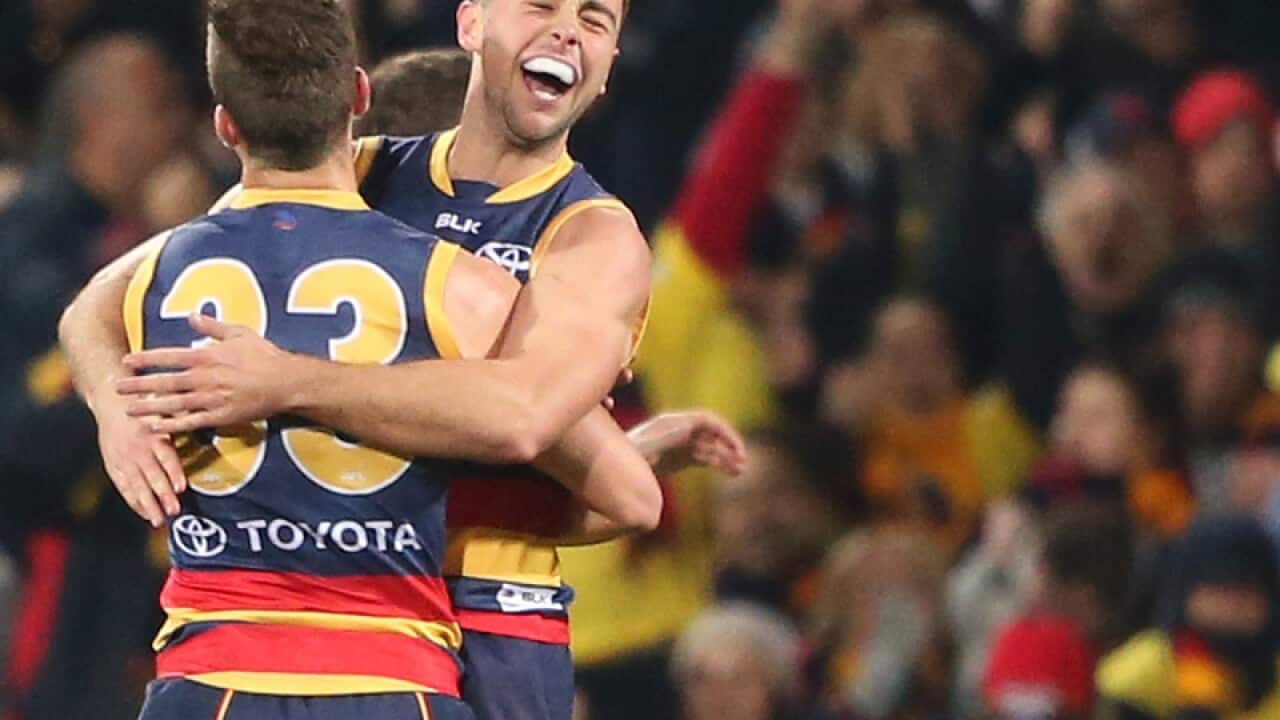 Rory Atkins of the Crows is congratulated by team mate Brodie Smith
