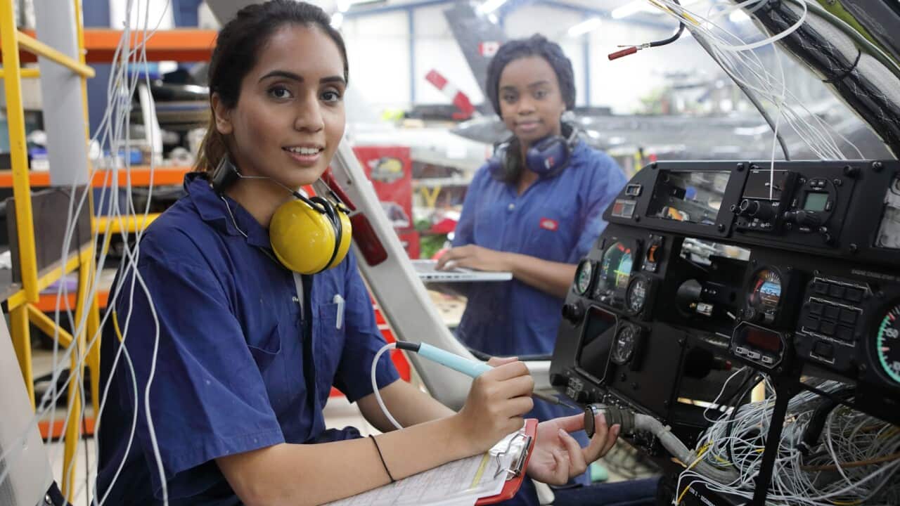 Young female engineers working with helicopters