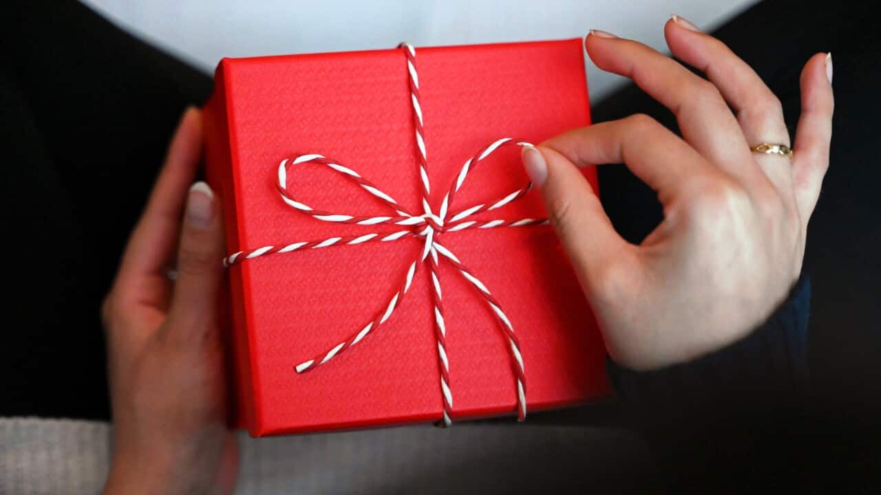 A hand holding a wrapped gift