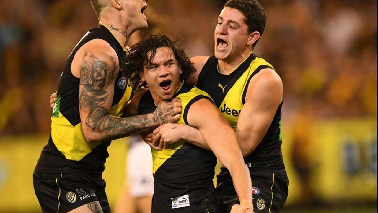 Dustin Martin, Daniel Rioli and Jason Castagna of the Tigers react.