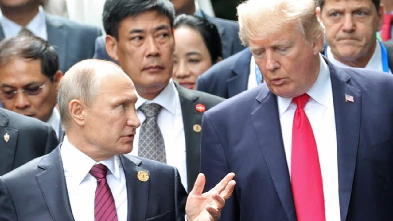 Donald Trump and Vladimir Putin talk during a photo session at the APEC summit in Vietnam.