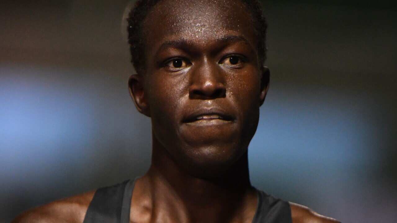 Joseph Deng with sweat on his face after running a race.