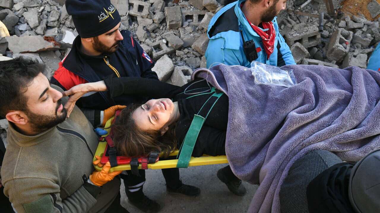 Rescuers pull a woman from the earthquake rubble (AAP).jpg