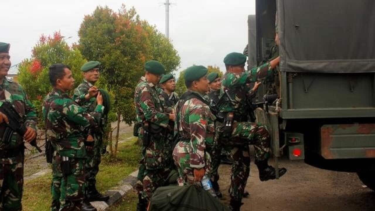 Indonesian soldiers get on to the vehicle as they arrive at Domine Eduard Osok Airport to be deployed to Sorong and Manokwari following the protests in Sorong, West Papua, Indonesia, August 20, 2019.