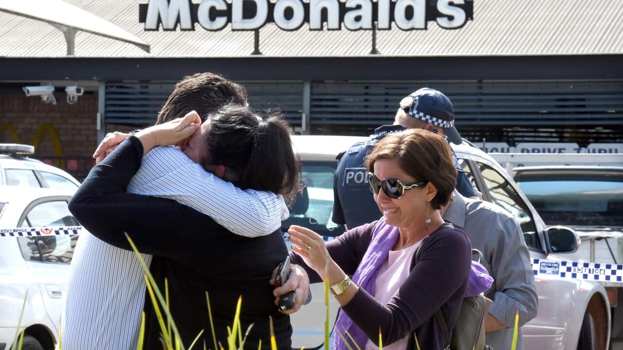 People react following a shooting at a McDonalds restaurant in Helensvale on the Gold Coast, Thursday, Sept. 10, 2015. (AAP Image/Dave Hunt) NO ARCHIVING