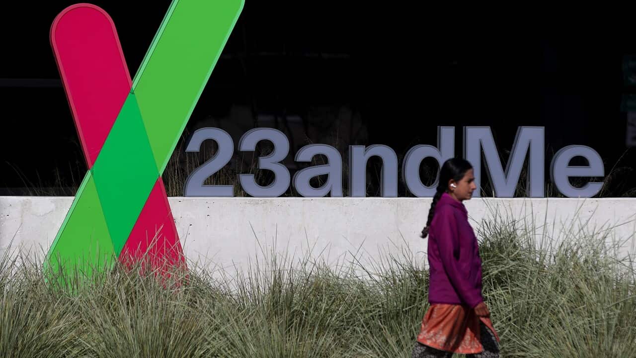 A woman walks past a building showing a 23andMe sign