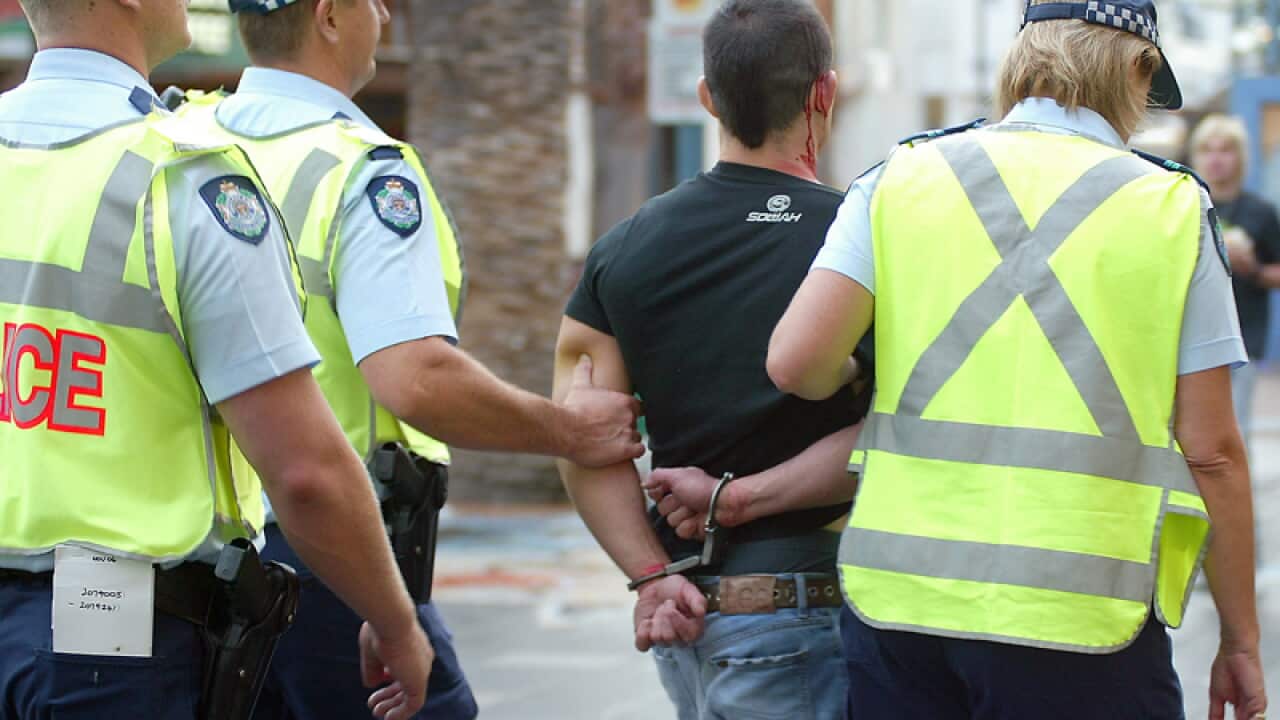 Police officers arrest an unidentified male during Schoolies week.