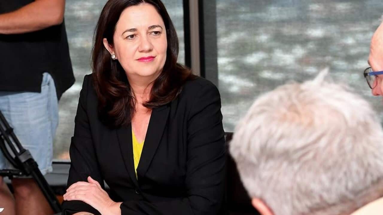 Queensland Premier Annastacia Palaszczuk (l) speaks during a meeting.