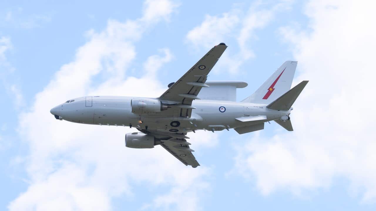 A grey military aircraft that looks similar to a passenger jet, in flight