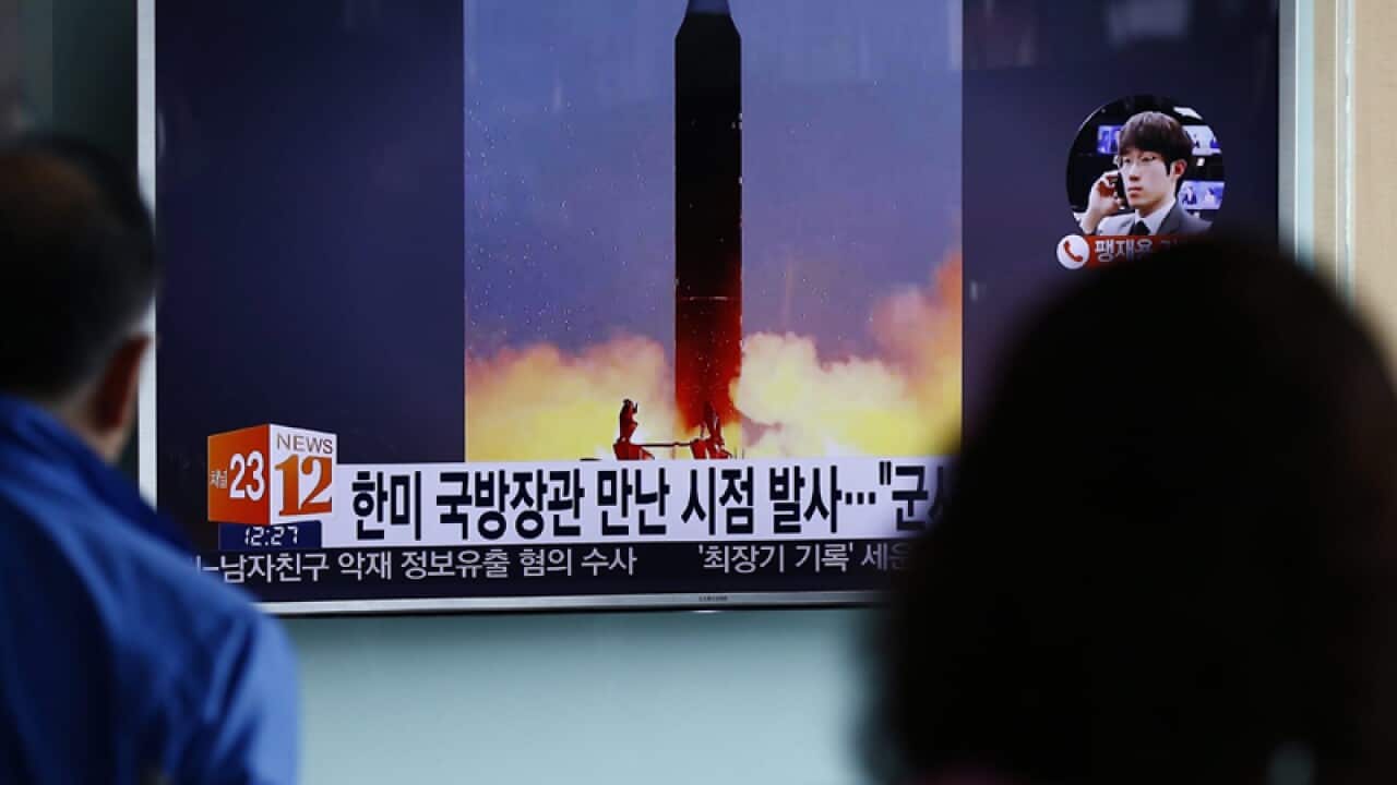 South Koreans watch a TV broadcast at a station in Seoul