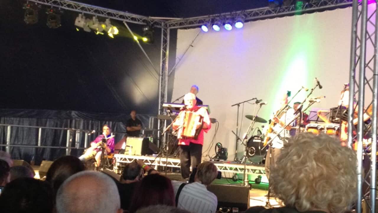 Rolf Harris on stage before answering bail