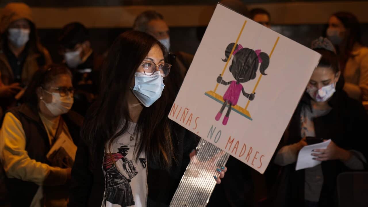 A woman holds a banner with a message that reads in Spanish, "Girls not mothers" during an abortion rights demonstration, in La Paz, Bolivia