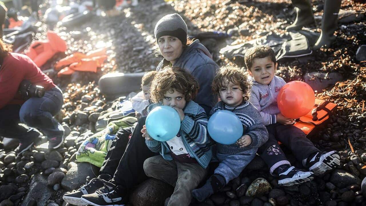 A displaced Yazidi woman, who fled violence from IS group jihadists, sits with her children on the shores of the Greek island of Lesbos