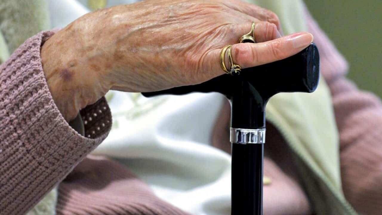 A woman uses a walking stick to assist her mobility in Canberra